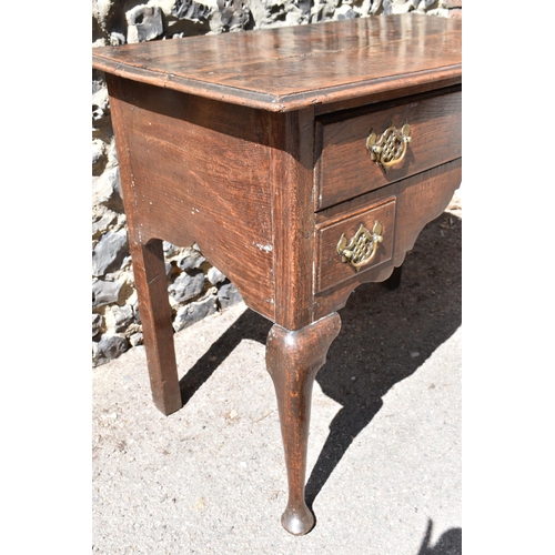 138 - A George III oak kneehole dressing table, with frieze drawer above two small dummy drawers, on cabri... 