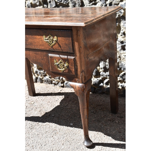 138 - A George III oak kneehole dressing table, with frieze drawer above two small dummy drawers, on cabri... 