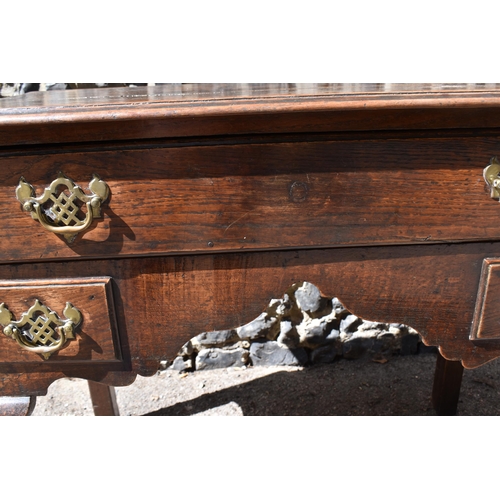 138 - A George III oak kneehole dressing table, with frieze drawer above two small dummy drawers, on cabri... 