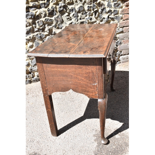 138 - A George III oak kneehole dressing table, with frieze drawer above two small dummy drawers, on cabri... 