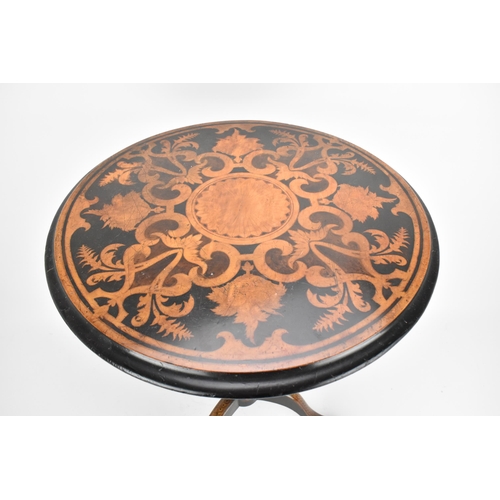 142 - A Victorian walnut and marquetry tilt top wine table, the circular top with inlaid c-scrolls and fol... 