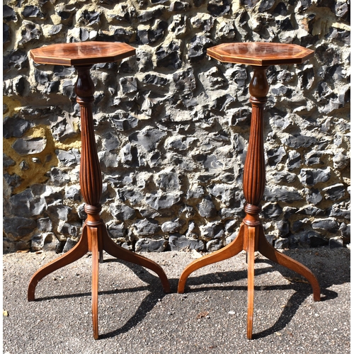 143 - A pair of Edwardian mahogany torcheres, in the Georgian style, the octagonal tops with flame veneer,... 