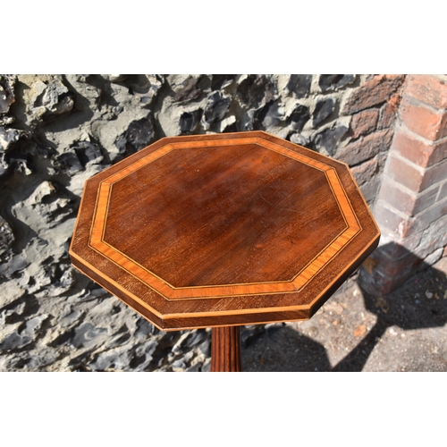 143 - A pair of Edwardian mahogany torcheres, in the Georgian style, the octagonal tops with flame veneer,... 