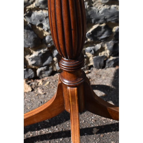 143 - A pair of Edwardian mahogany torcheres, in the Georgian style, the octagonal tops with flame veneer,... 