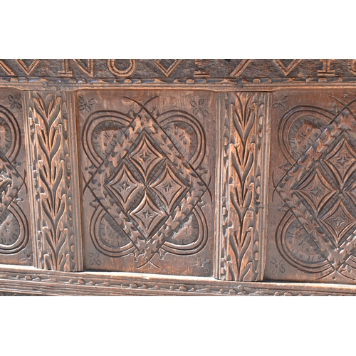 149 - A late 17th century oak coffer, with four carved panel top and foliate carved four panel front on st... 