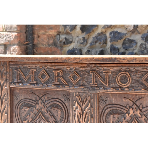 149 - A late 17th century oak coffer, with four carved panel top and foliate carved four panel front on st... 