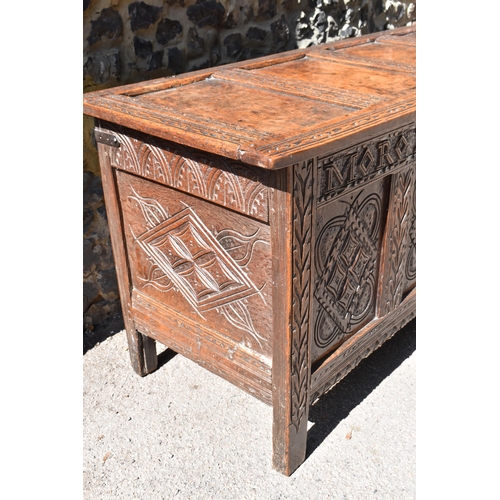 149 - A late 17th century oak coffer, with four carved panel top and foliate carved four panel front on st... 