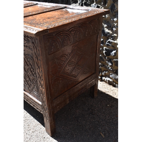 149 - A late 17th century oak coffer, with four carved panel top and foliate carved four panel front on st... 