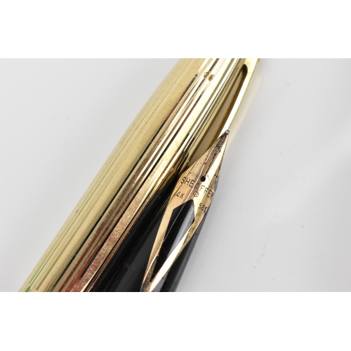 74 - A Sheaffer gold-plated fountain pen, with 14ct yellow gold nib, stamped 585, of tapered form with pa... 