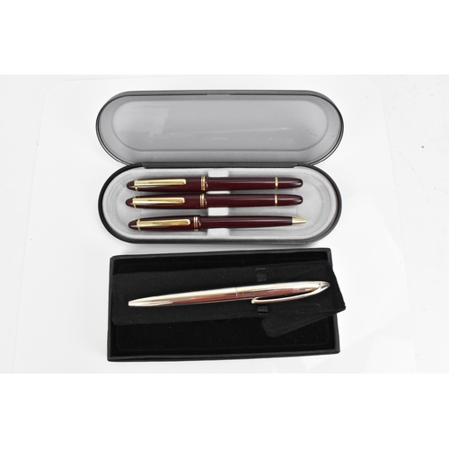 84 - A cased set of pens, comprising two fountain and one ballpoint pen, each with maroon barrel and gilt... 