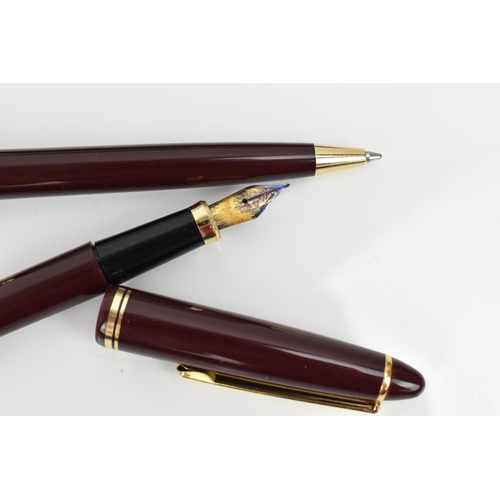 84 - A cased set of pens, comprising two fountain and one ballpoint pen, each with maroon barrel and gilt... 