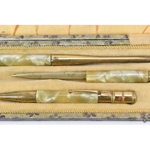 82 - An early 20th century Art Deco cased desk set, in marbled bakelite and gold coloured metal, comprisi... 