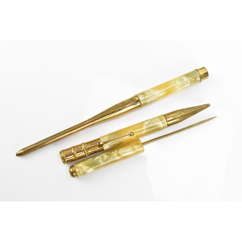 82 - An early 20th century Art Deco cased desk set, in marbled bakelite and gold coloured metal, comprisi... 