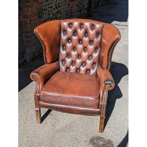 321 - A mid 20th century brown leather 'Chesterfield' wingback armchair on front fluted legs 
Location: A2... 