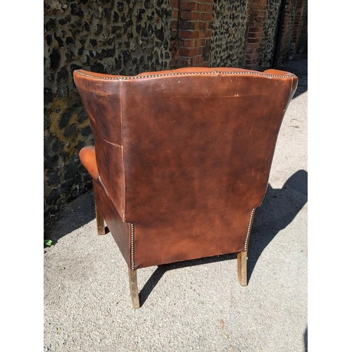 321 - A mid 20th century brown leather 'Chesterfield' wingback armchair on front fluted legs 
Location: A2... 