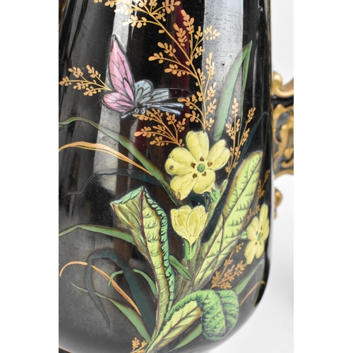 225 - A late Victorian trio of enamelled pottery, comprising a central vase and two jugs, each decorated w... 