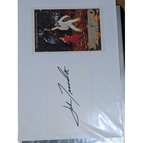 320 - A folder of signed postcards, photographs and photographic prints to include John Travolta, Bert Wee... 