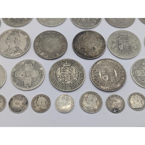 44 - A collection of British Victorian silver coins to include 12 half crowns, 5 'Gothic' florins 1899 an... 