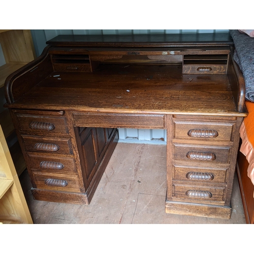 295 - A 1930's/40's oak roll top twin pedestal desk having a fitted interior and nine drawers, 109cm h x 1... 