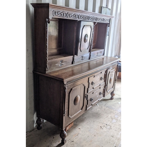 326 - An early 20th century oak sideboard having open shelves above two drawers flanked by two cupboard 17... 