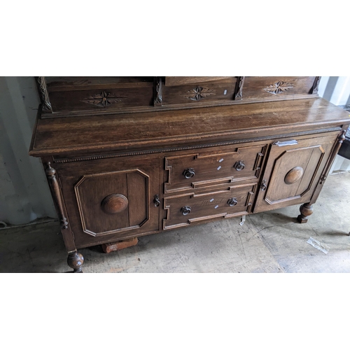 326 - An early 20th century oak sideboard having open shelves above two drawers flanked by two cupboard 17... 