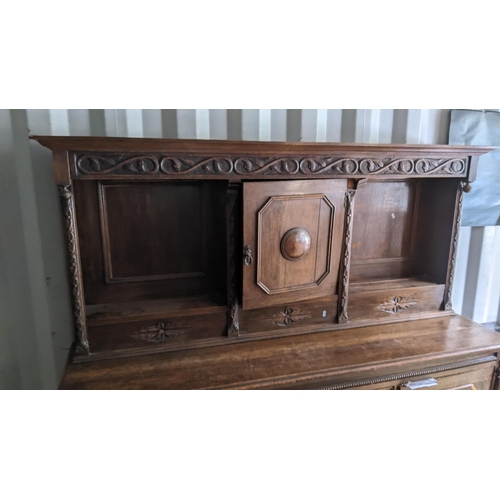 326 - An early 20th century oak sideboard having open shelves above two drawers flanked by two cupboard 17... 