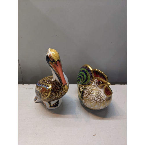 102 - Four Crown Derby paperweights to include Brown Pelican with silver stopper, farmyard cockerel with  ... 