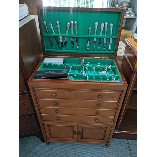 110 - A vintage Chinese cutlery cabinet having a hinged top with drawers and cupboards below, containing m... 