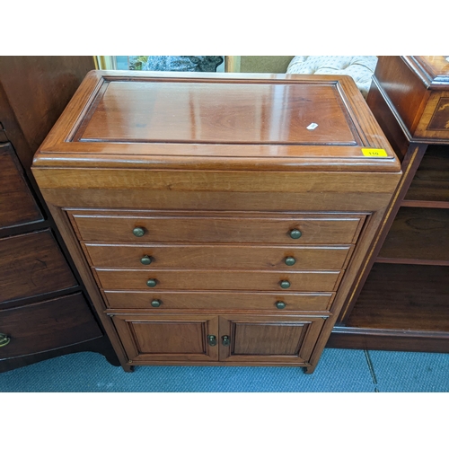 110 - A vintage Chinese cutlery cabinet having a hinged top with drawers and cupboards below, containing m... 