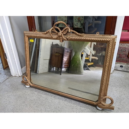 394 - A gilt framed overmantle mirror with rope and bow decoration rectangular plate glass 67 x 97 cms
Loc... 