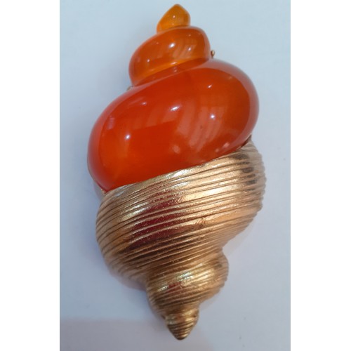 Christian Dior-A late 1980's gold tone and orange resin brooch in the form of a shell designed by Robert Goosens in 1987 for the launch of the perfume 'Dune'. Measurements 10cm x5cm. Stamped Christian Dior Parfums to the reverse together with a grey branded fabric pouch.
Location: CAB1