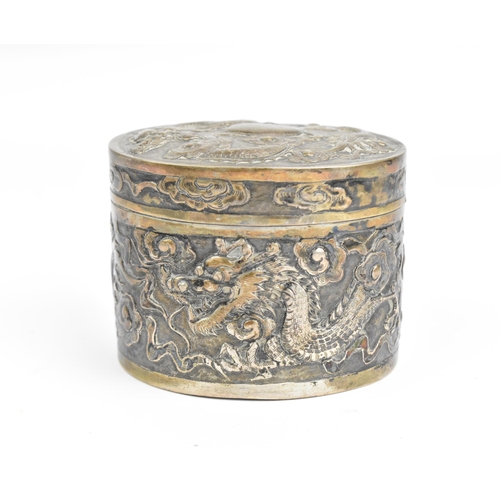 117 - A Chinese export silver oval lidded box, circa 1900, embossed with dragons in clouds, the underside ... 