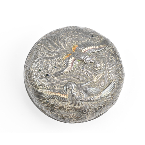 118 - A Japanese white metal and enamel circular box, the lid with raised decoration of birds in paradise ... 