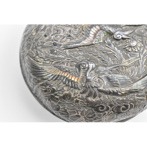 118 - A Japanese white metal and enamel circular box, the lid with raised decoration of birds in paradise ... 