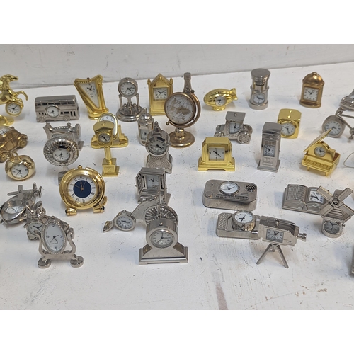 121 - A collection of approx 70 miniature novelty quartz clocks in various forms to include Ship, Car, Pip... 