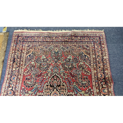 10 - A Persian hand woven, red ground rug having a central motifs, floral design and multiguard borders, ... 