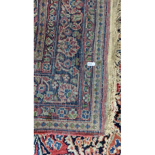 10 - A Persian hand woven, red ground rug having a central motifs, floral design and multiguard borders, ... 