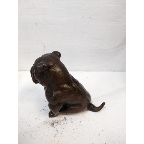 106 - An early 20th century small bronze model of a seated bulldog, along with a carved onyx sculpture of ... 