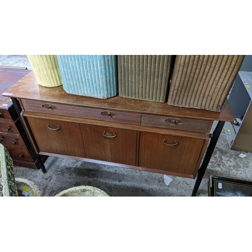 13 - A mid 20th century Nathan teak and ebonized sideboard with three reeded drawers and three doors, 84H... 