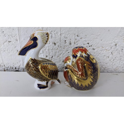 18 - A Royal Crown Derby Pelican paperweight with gold stopper, together with two monkey paperweights wit... 