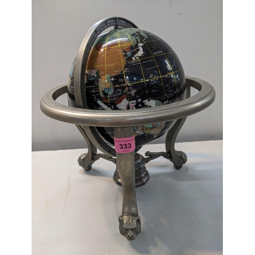 333 - A globe set with semi and non-precious stones set in a metal supporting frame on lion and ball feet
... 