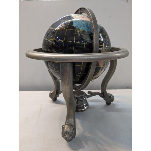 333 - A globe set with semi and non-precious stones set in a metal supporting frame on lion and ball feet
... 