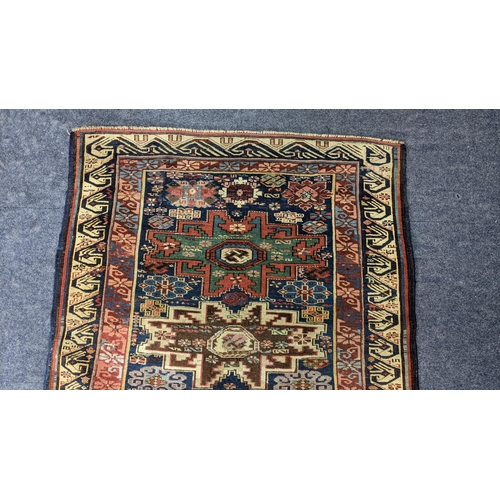 44 - A Turkish hand woven rug having a blue ground with four motifs and beige border, 146 x 104.5, Locati... 