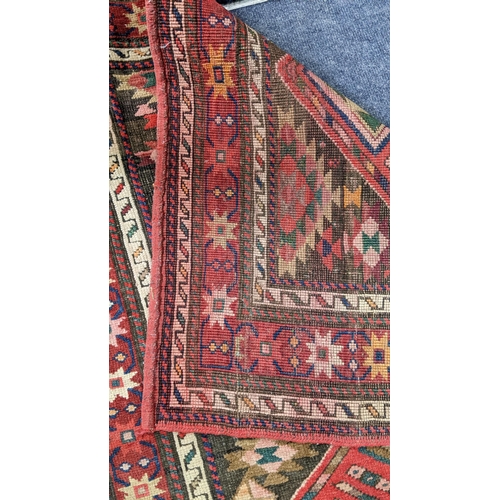 6 - A Kurdish hand woven runner having seven diamond motifs on a red ground, 327 x 96, Location: LWM