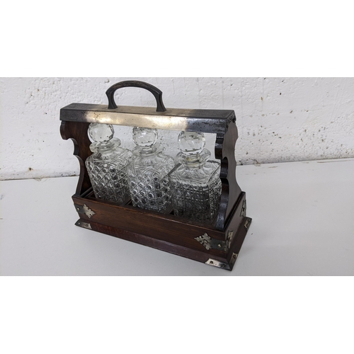 62 - An early 20th century oak Tantalus with silver plated mounts, Location: 11.1