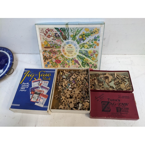 79 - A group of three jigsaw puzzles in original boxes to include one depicting the coloured pages The Ta... 