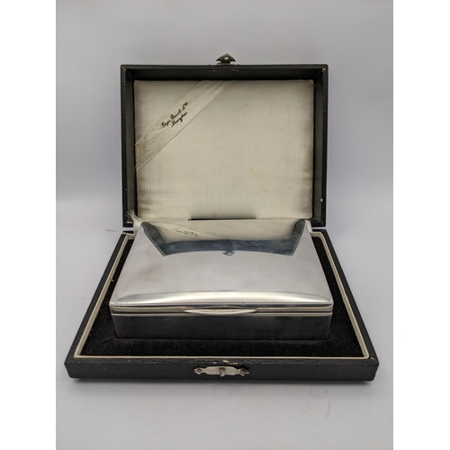 280 - A white metal cigarette box having wooden interior and marks to base, together with fitted presentat... 