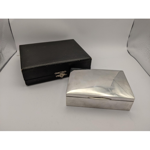 280 - A white metal cigarette box having wooden interior and marks to base, together with fitted presentat... 