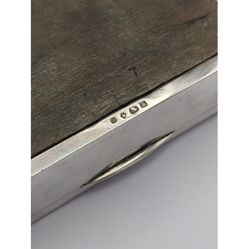 280 - A white metal cigarette box having wooden interior and marks to base, together with fitted presentat... 