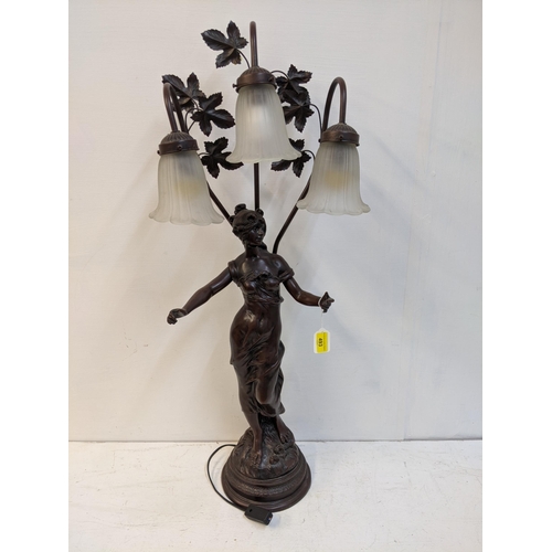 168 - A reproduction of a bronzed finished Art Nouveau style table lamp, fashioned as a woman with three g... 